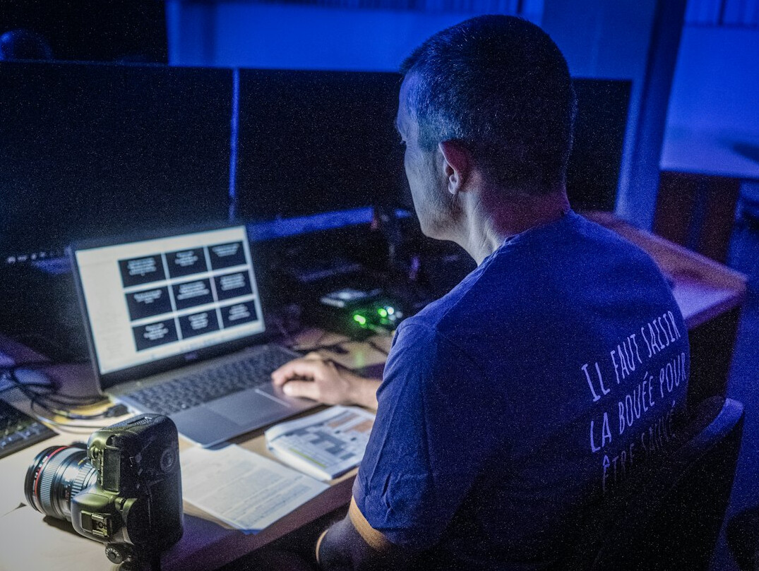 Broadcast engineer monitoring a live video stream on a laptop